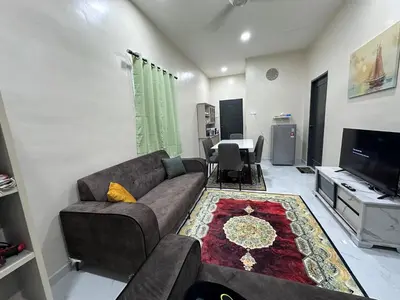 a living room with a couch and a tv at Anjang Pat Kesang Laut Homestay in Gua Sai
