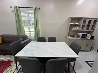 a table and chairs in a living room with a couch at Anjang Pat Kesang Laut Homestay in Gua Sai