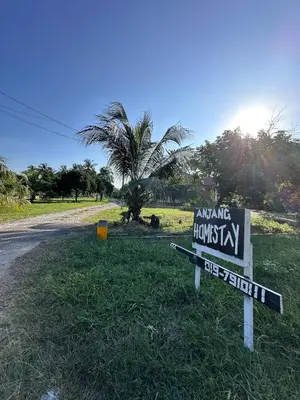 a sign in the grass next to a street at Anjang Pat Kesang Laut Homestay in Gua Sai