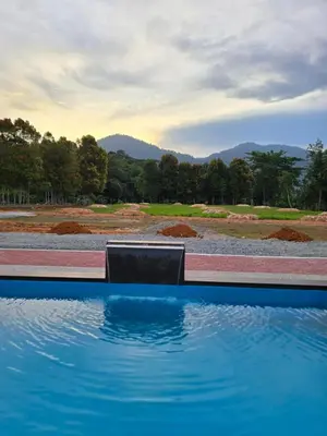 a swimming pool with blue water in the foreground at D Tasek Homestay Lenggong