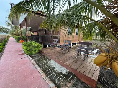a house with a wooden deck with two picnic tables at Akira Laman Padi Tg Karang in Tanjung Karang