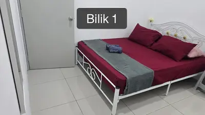 a bedroom with a bed with red sheets and a camera on it at Dee Intan Homestay, Ipoh - Malay Only in Ipoh
