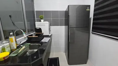 a small kitchen with a sink and a refrigerator at Dee Intan Homestay, Ipoh - Malay Only in Ipoh