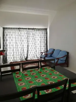 a living room with a table and a couch at Cikgu Husni Homestay Apartment Cameron Highlands in Tanah Rata