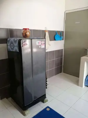 a kitchen with a stainless steel refrigerator in a room at Cikgu Husni Homestay Apartment Cameron Highlands in Tanah Rata