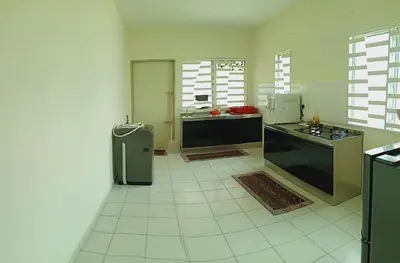 a large kitchen with a refrigerator and a counter at Nausha Homestay Mus-lim ONLY in Kulim