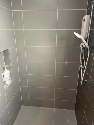 a bathroom with a shower with a tiled wall at Dream Home Landed Balik Pulau in Balik Pulau
