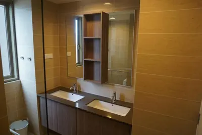 a bathroom with two sinks and a mirror and a toilet at Ferringhi Luxury Suite @ By The Sea in Batu Ferringhi