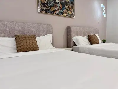 two beds sitting next to each other in a room at Warm & Cozy Home in Kampong Duson Gilap