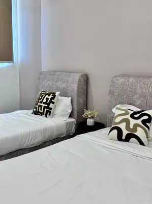 a bedroom with two beds and a chair at Warm & Cozy Home in Kampong Duson Gilap
