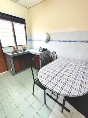 a kitchen with a table and chairs in a room at D'Manjung Samudera Baru HomeSTAY in Seri Manjung