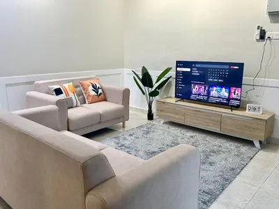 a living room with a couch and a tv at Vintage-Living 2Storey Haus12Pax in Simpang Ampat