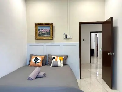 a bedroom with a bed with pillows on it at Vintage-Living 2Storey Haus12Pax in Simpang Ampat
