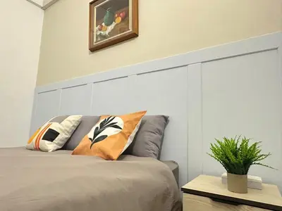 a bed with pillows on it in a room at Vintage-Living 2Storey Haus12Pax in Simpang Ampat