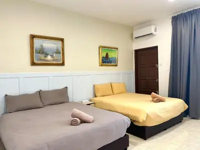 two beds in a room with blue curtains at Vintage-Living 2Storey Haus12Pax in Simpang Ampat