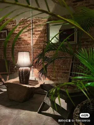 a living room with a lamp in a brick wall at Bitterswiit Ladies Hostel in George Town