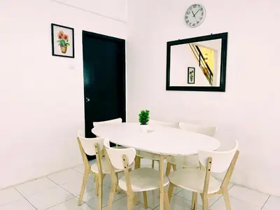 a white dining room with a white table and chairs at Homestay Sungai Petani 4 Bedroom in PRIMA Bandar Puteri Jaya by D'Aleena Homes in Sungai Petani