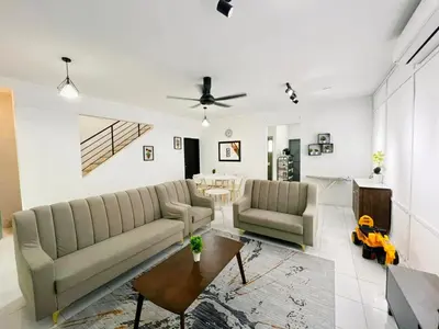 a living room with two couches and a table at Homestay Sungai Petani 4 Bedroom in PRIMA Bandar Puteri Jaya by D'Aleena Homes in Sungai Petani