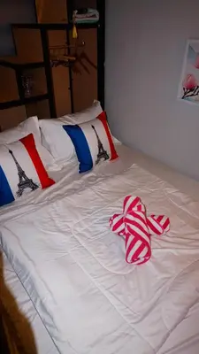 a white bed with red and white towels on it at Cozy Loft Bed Mini Studio Golf View in Gua Sai