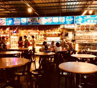 a group of people sitting at tables in a restaurant at 12pax 3-Bedroom l Seaview l Georgetown l Gleneagles l Mansion One in George Town