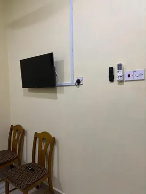 a room with two chairs and a tv on a wall at Ray Yan Guesthouse Penang in Batu Ferringhi