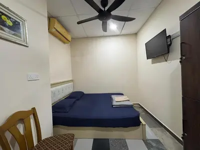a small room with a bed and a ceiling fan at Ray Yan Guesthouse Penang in Batu Ferringhi
