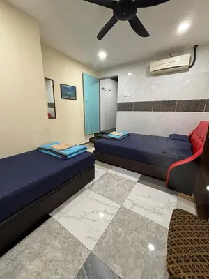 a room with two beds and a ceiling fan at Ray Yan Guesthouse Penang in Batu Ferringhi