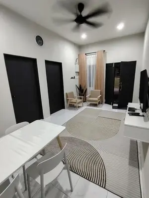 a living room with a ceiling fan and a table and chairs at Homestay De'daun kulim mus'lim only in Kulim