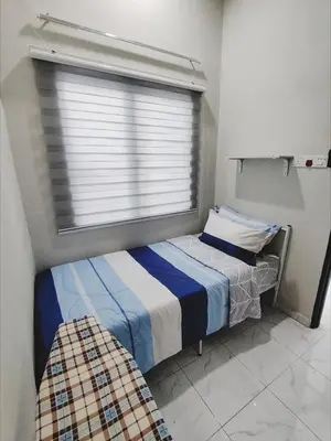 a bedroom with two beds and a window at Homestay De'daun kulim mus'lim only in Kulim
