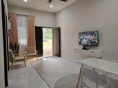 a living room with a tv on a wall at Homestay De'daun kulim mus'lim only in Kulim