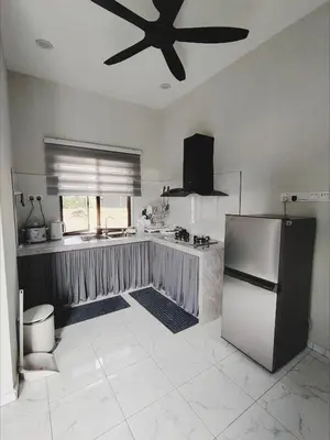 a kitchen with a refrigerator and a ceiling fan at Homestay De'daun kulim mus'lim only in Kulim