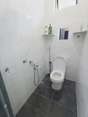 a white bathroom with a toilet and a shower at Homestay De'daun kulim mus'lim only in Kulim