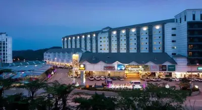 a large building with a parking lot in front of it at Nova hotel in Brinchang