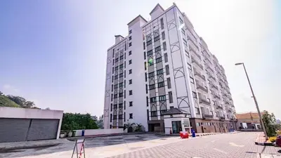 a large white building on the side of a street at Nova hotel in Brinchang