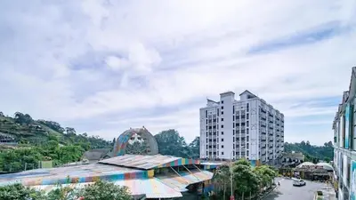 a building with a rainbow roof next to a tall building at Nova hotel in Brinchang