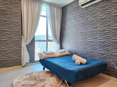 a blue bed in a room with a window at Stylish Living 2BR Suite in George Town