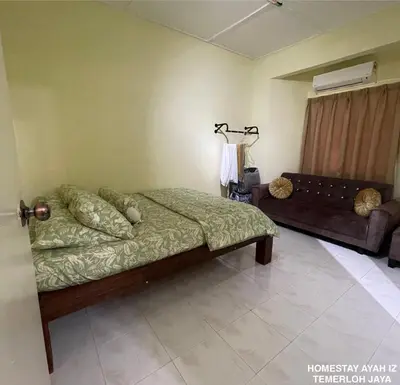 a bedroom with a bed and a couch at Homestay Ayah Iz Temerloh Jaya in Gua Sai