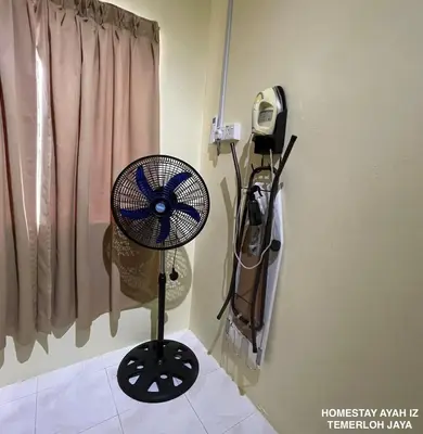 a fan in the corner of a room at Homestay Ayah Iz Temerloh Jaya in Gua Sai