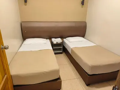two beds in a small room with two beds sidx sidx sidx at The Pines Hotel in Tanah Rata