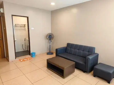 a living room with a couch and a fan at The Pines Hotel in Tanah Rata