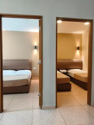 a hotel room with two beds and a mirror at The Pines Hotel in Tanah Rata