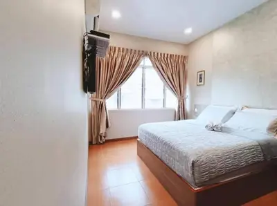 a bedroom with a large bed and a window at Homestay Lung Tok in Bukit Mertajam