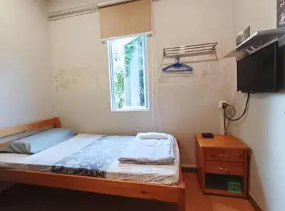 a bedroom with a bed and a window and a television at Homestay Lung Tok in Bukit Mertajam