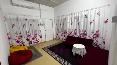 a living room with a red couch and flowers on the wall at D'Simpang Homestay in Sungai Petani