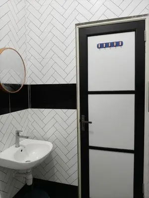 a bathroom with a white sink and a door at Adila Alfina Heaven Homestay Cameron Highlands in Tanah Rata
