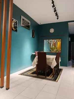 a dining room with a table and a blue wall at Adila Alfina Heaven Homestay Cameron Highlands in Tanah Rata