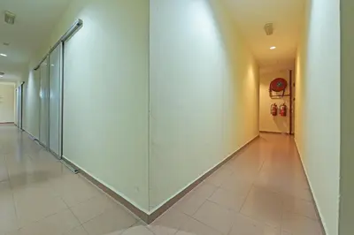 a hallway with glass doors in a building at SPOT ON 91178 Motel Impian in Kampong Telok Batu