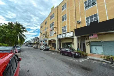 a city street with cars parked in front of buildings at SPOT ON 91178 Motel Impian in Kampong Telok Batu