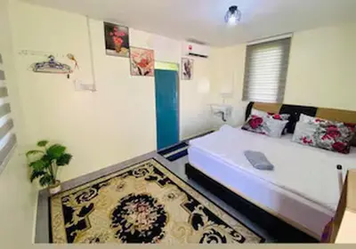 a bedroom with a large bed and a rug at Capital O 91180 Mentari Senja Homestay in Kampong Dekeh