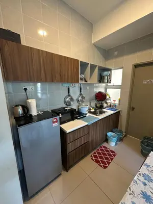 a kitchen with a refrigerator and a counter top at AYAAN PENTHOUSE at Golden Hill Night Market View in Brinchang